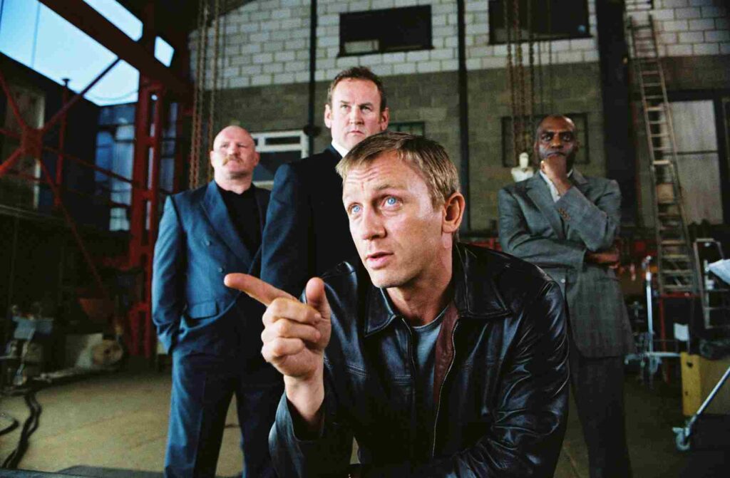 Daniel Craig as XXXX with part of his crew in a warehouse in Layer Cake.